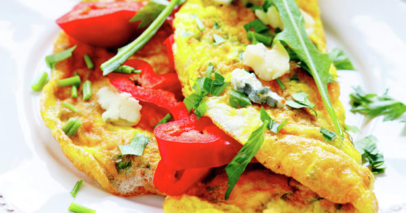 Omelette with red peppers, arugula on a white plate