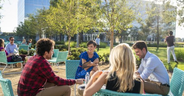 Photography of people enjoying The Commons, an outdoor workplace and gathering area, at The Quad at Discovery Park in Irvine, CA