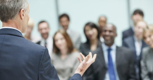 Businesspeople at a conference listening to a male speaker
