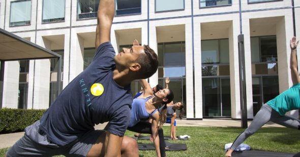 A group of people doing yoga as part of a KINETIC® group fitness class