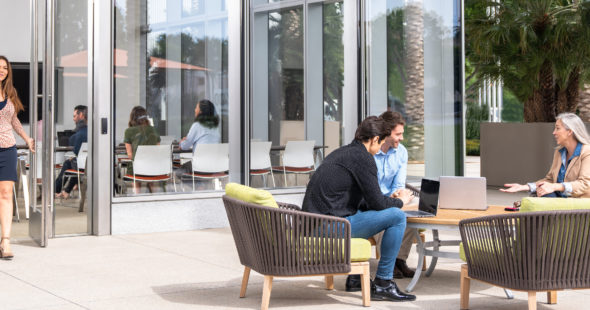 Photography of people using the outdoor seating areas and nearby conference room at 400 Spectrum Center Drive in Irvine, CA