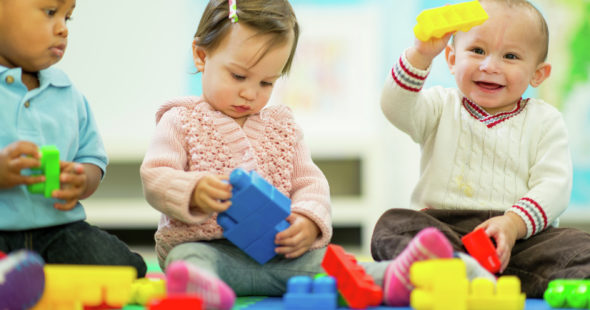 Infants playing with toy Lego blocks